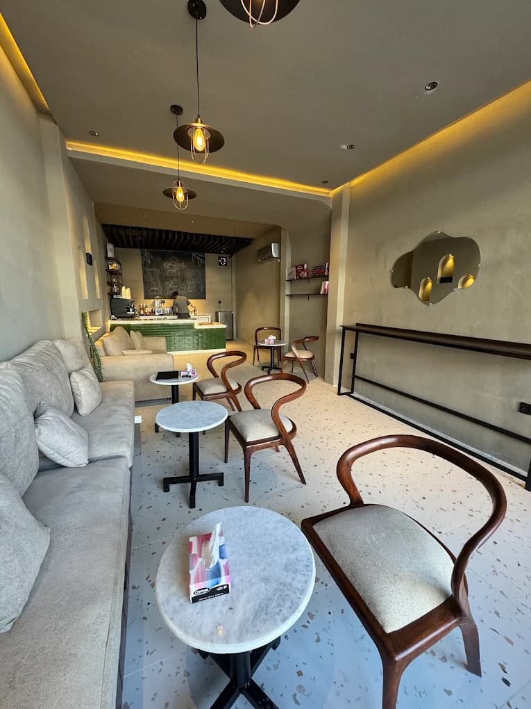 Minimal cafe interior with sofa seating and chalkboard menu at The Commons Coffee